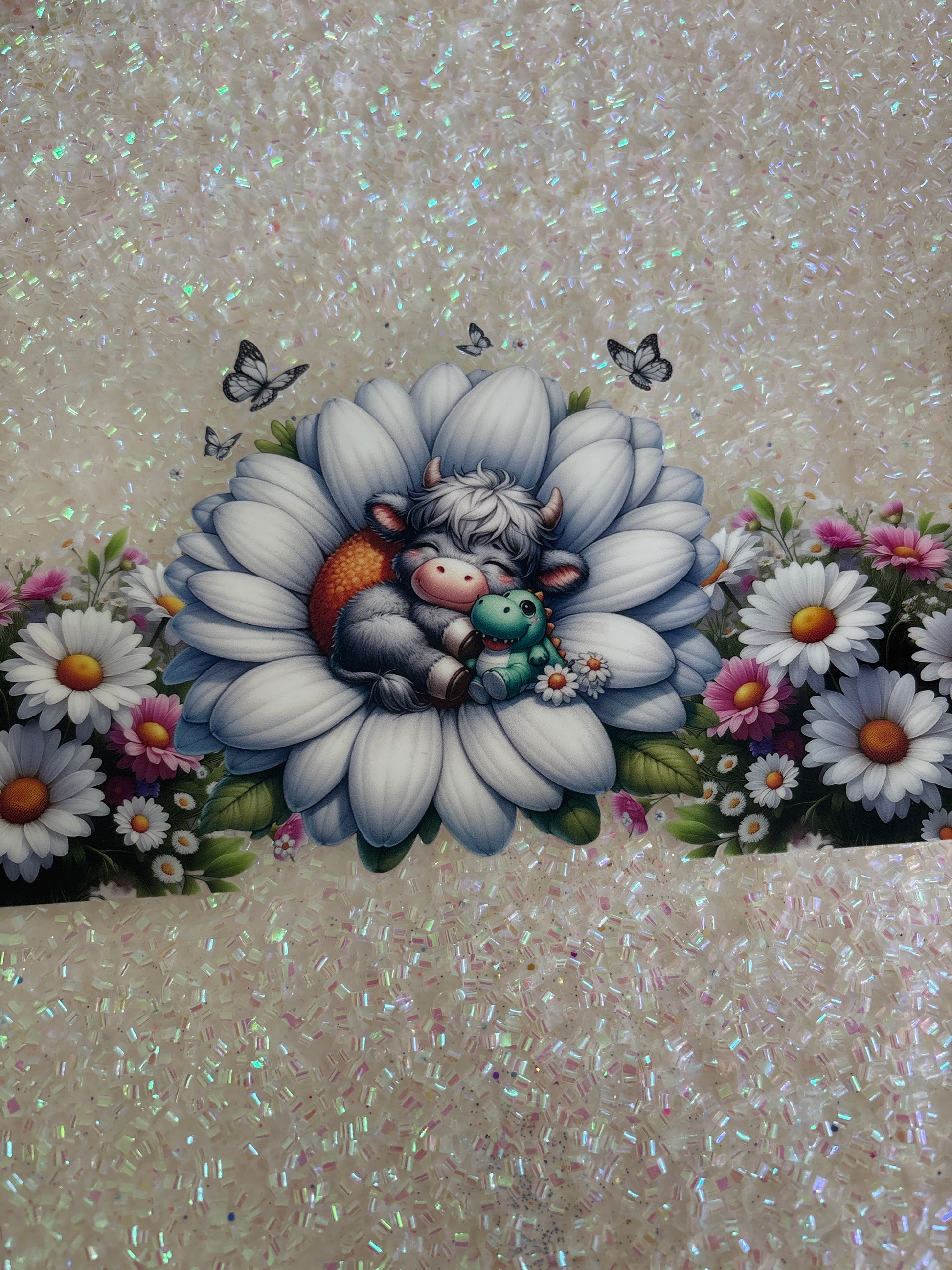 Grey baby Highland cow hugging a dinosaur in a flower with lid decal