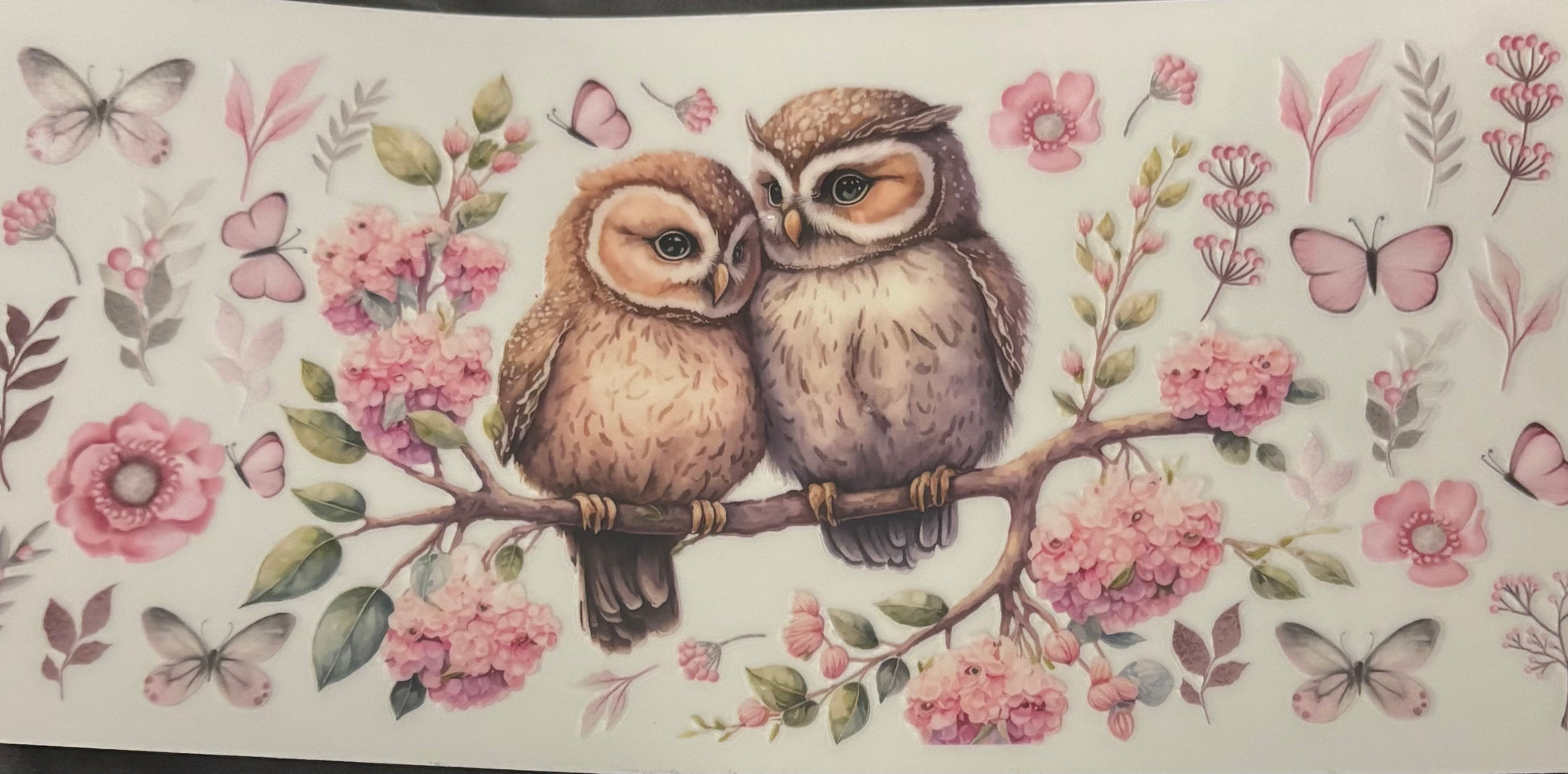 Two owls on a branch with pink flowers